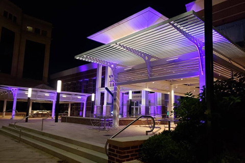 The sleek postmodern building was lit in radiant purple, gold and white